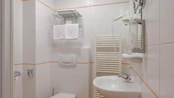 Une salle de bain avec des toilettes, un lavabo et une douche.