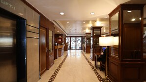 A hotel lobby with a marble floor, wooden furniture, and a reception desk. - Citizen Hotel (Mumbai)