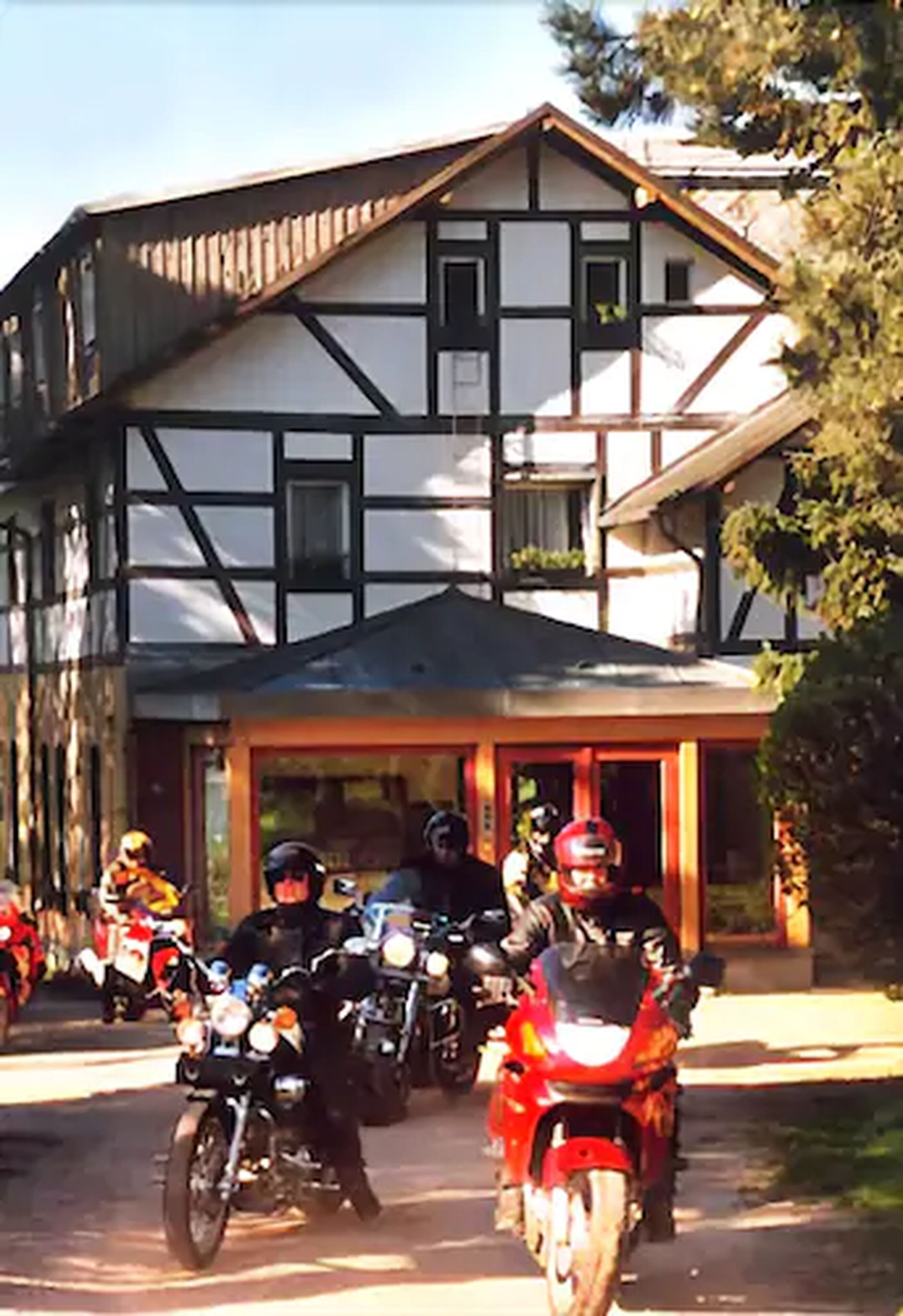 Motorräder sind vor einem Gebäude mit einer traditionellen Fachwerkfassade abgestellt.