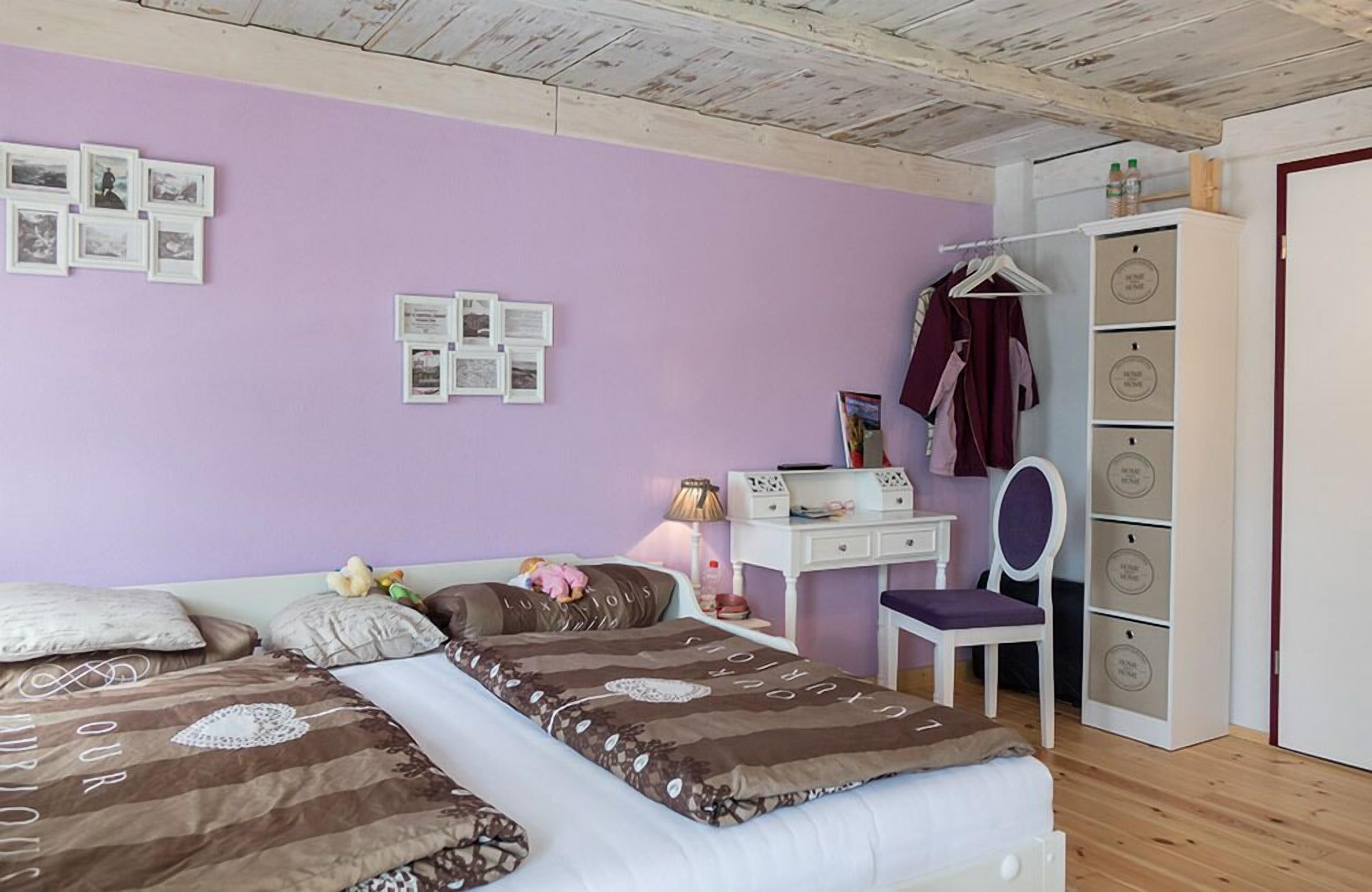Un dormitorio con dos camas, un escritorio, una silla y un armario.