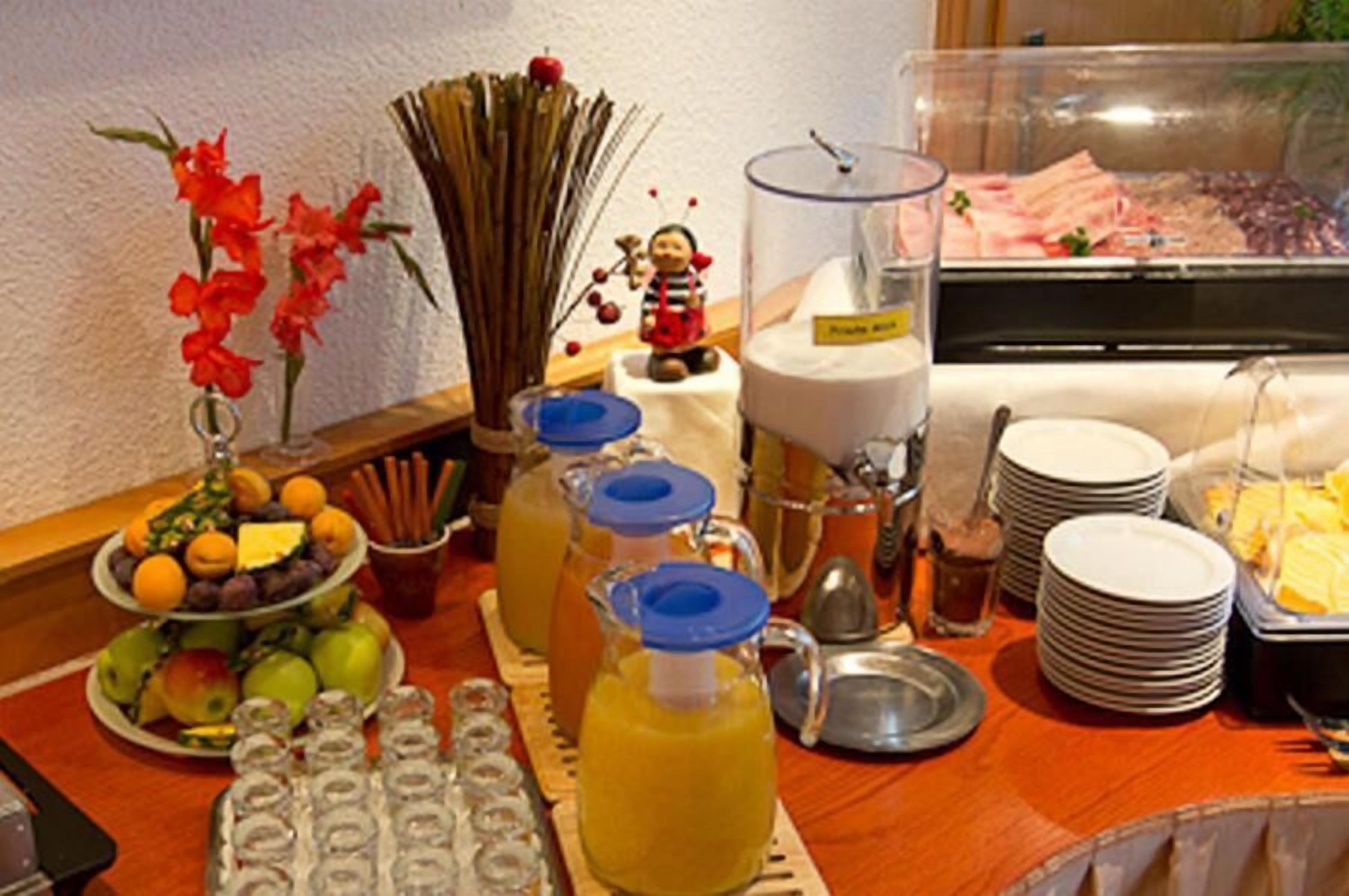 A buffet setup with various food items, including fruits, vegetables, and beverages.