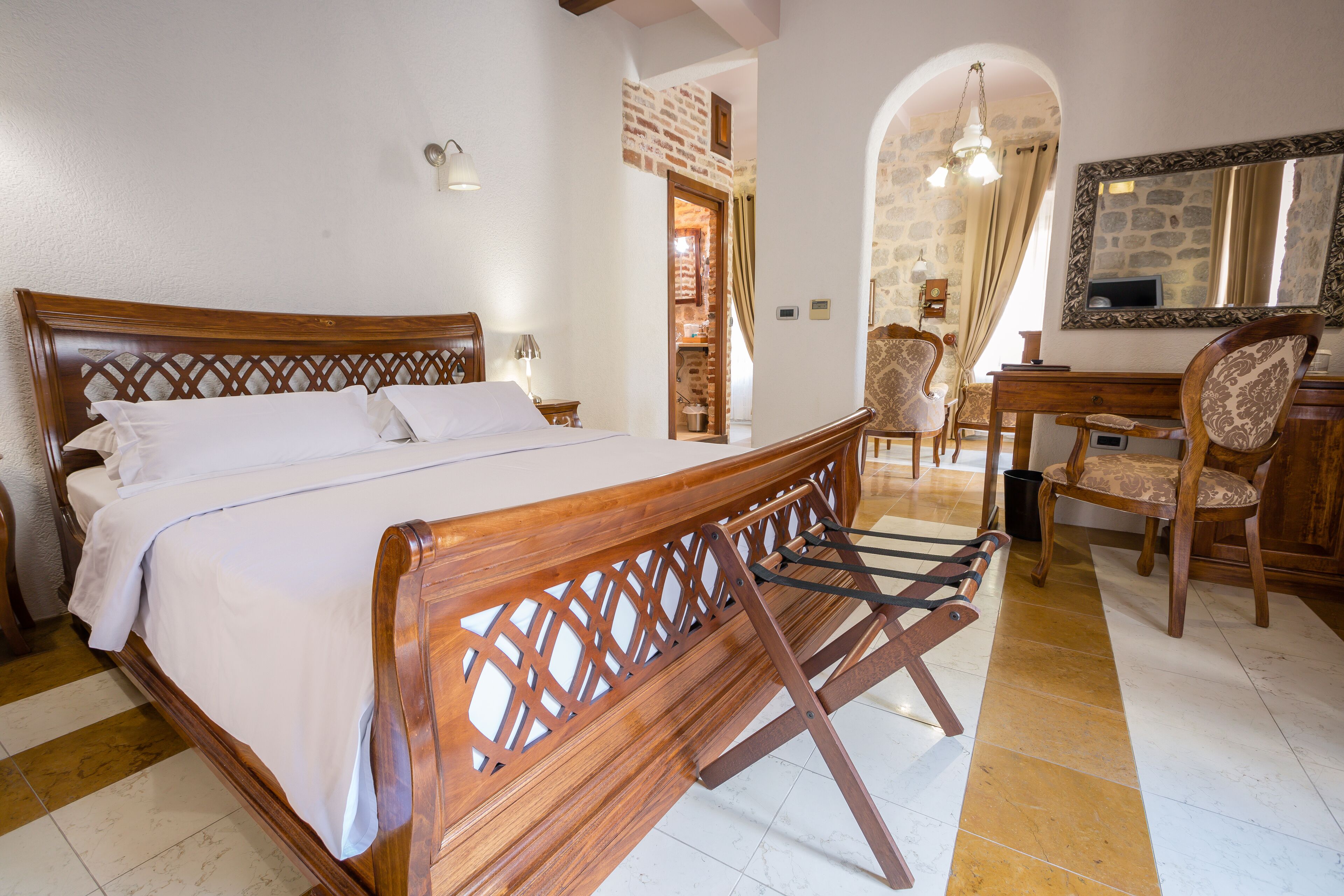 Un dormitorio con una cama de madera, un escritorio y una silla.