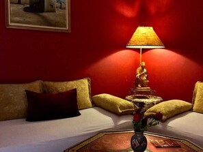 A room with a bed, a statue, a lamp, and a vase with flowers. - Dar Naciria Marrakech (Marrakech)