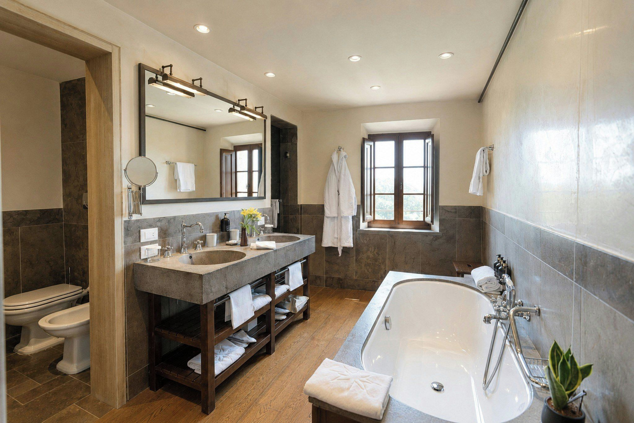 Un bagno moderno con una vasca da bagno spaziosa, un doppio lavabo, un water e uno spazio doccia.