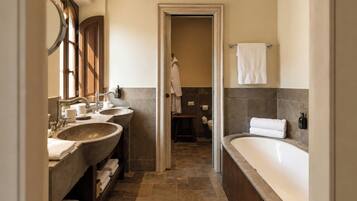 Un baño con dos lavamanos, una bañera y una zona de ducha.