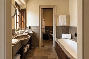 Un baño con dos lavamanos, una bañera y una zona de ducha.