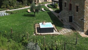 A courtyard with a swimming pool, stone buildings, and a lush green garden. - Castel Monastero - The Leading Hotels of the World (Castelnuovo Berardenga)