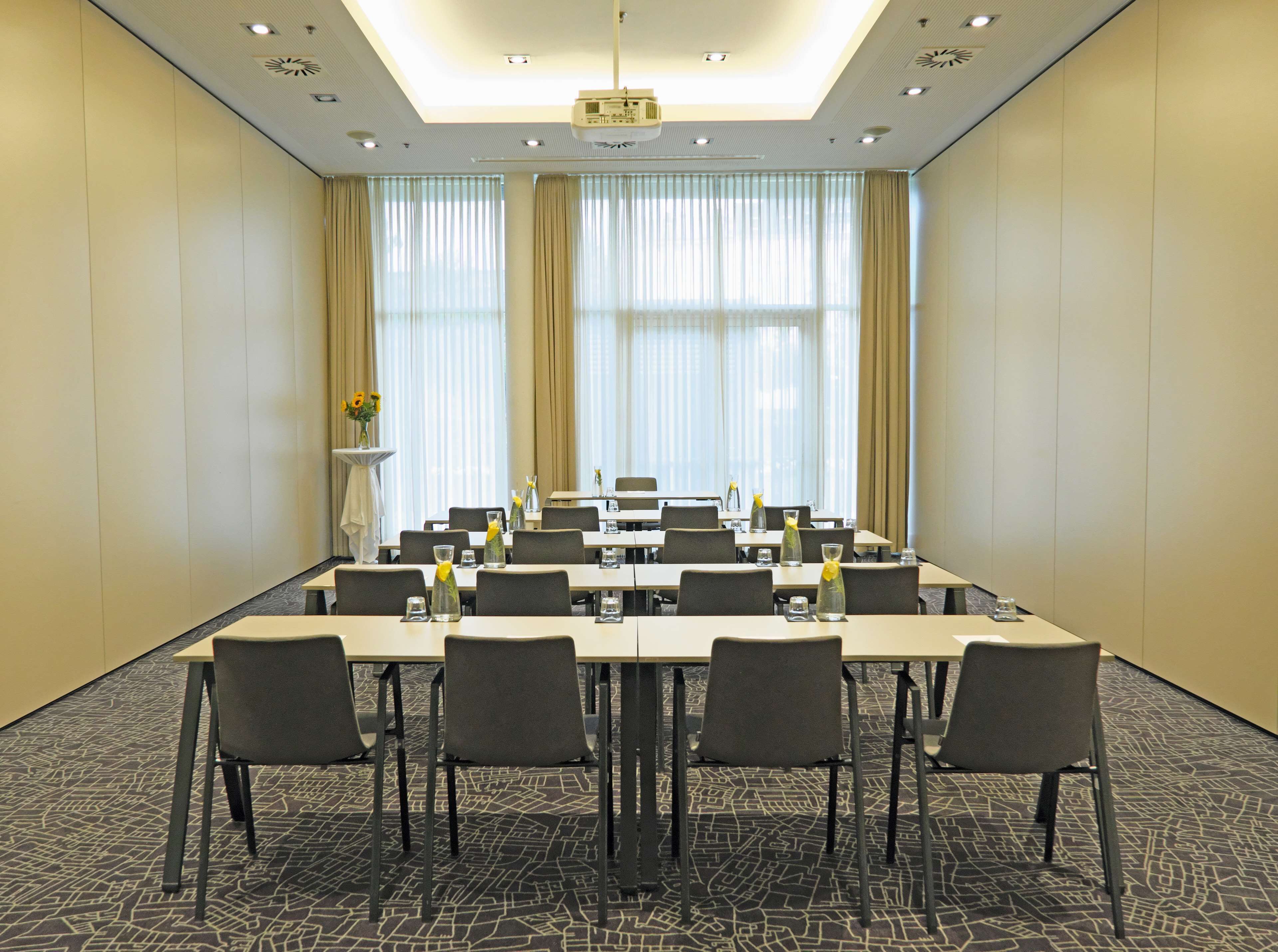A conference room with a long table, multiple chairs, and a projector.