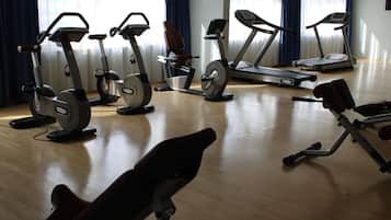A gym with various exercise equipment including stationary bikes, treadmills, and a rowing machine.