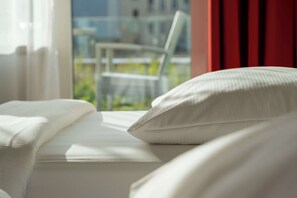 Ropa de cama hipoalergénica y caja de seguridad en la habitación