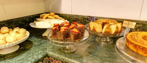Un bufé con diversos postres, incluyendo pasteles y repostería.