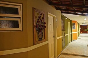 A hallway with a door, a framed artwork, and a tiled floor.