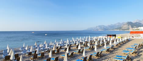 NĂ€ra stranden, svart sandstrand, solstolar och parasoller