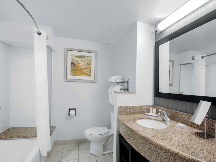 A modern bathroom with a shower, toilet, and sink.
