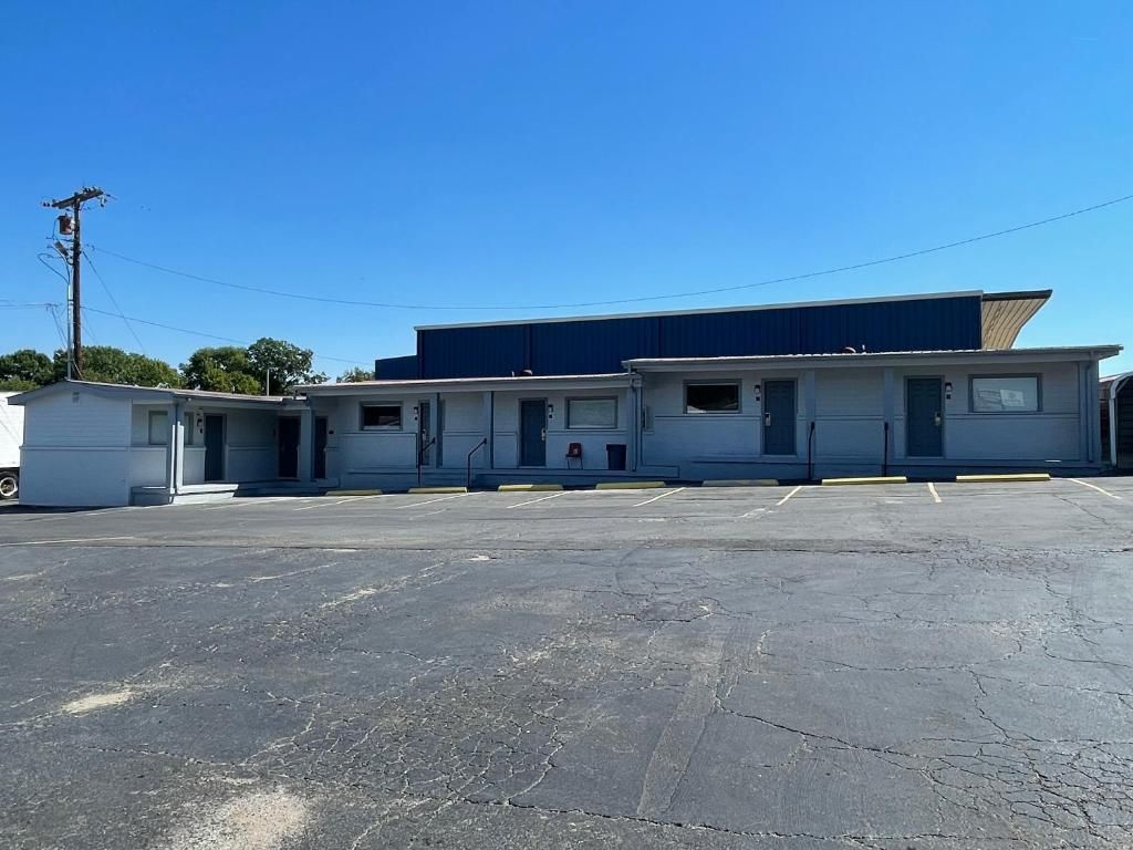 A row of single-story buildings with a parking lot in front.