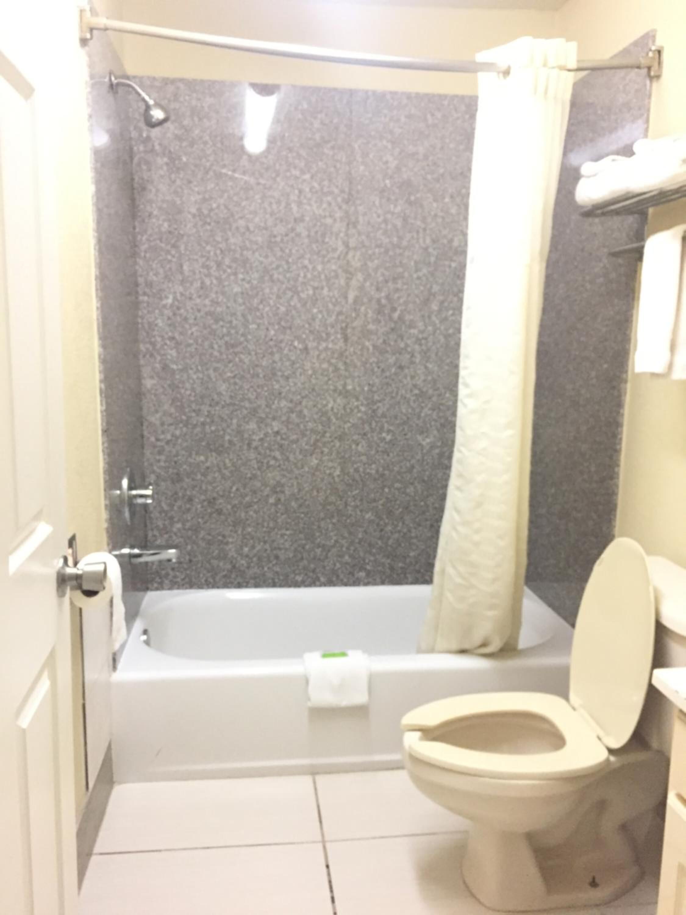 Une salle de bain avec une baignoire, des toilettes et un rideau de douche.
