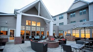 An outdoor patio area with seating, a fire pit, and a view of the building's interior. - Residence Inn By Marriott Columbus (Columbus)