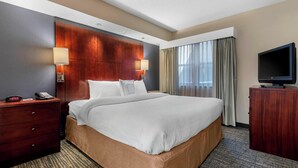 A hotel room with a large bed, wooden headboard, two bedside lamps, a TV, a dresser, and a telephone on the nightstand. - Residence Inn By Marriott Columbus (Columbus)
