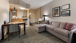 A modern hotel room with a kitchenette, a dining area, a sofa, and a large window. - Residence Inn By Marriott Columbus (Columbus)