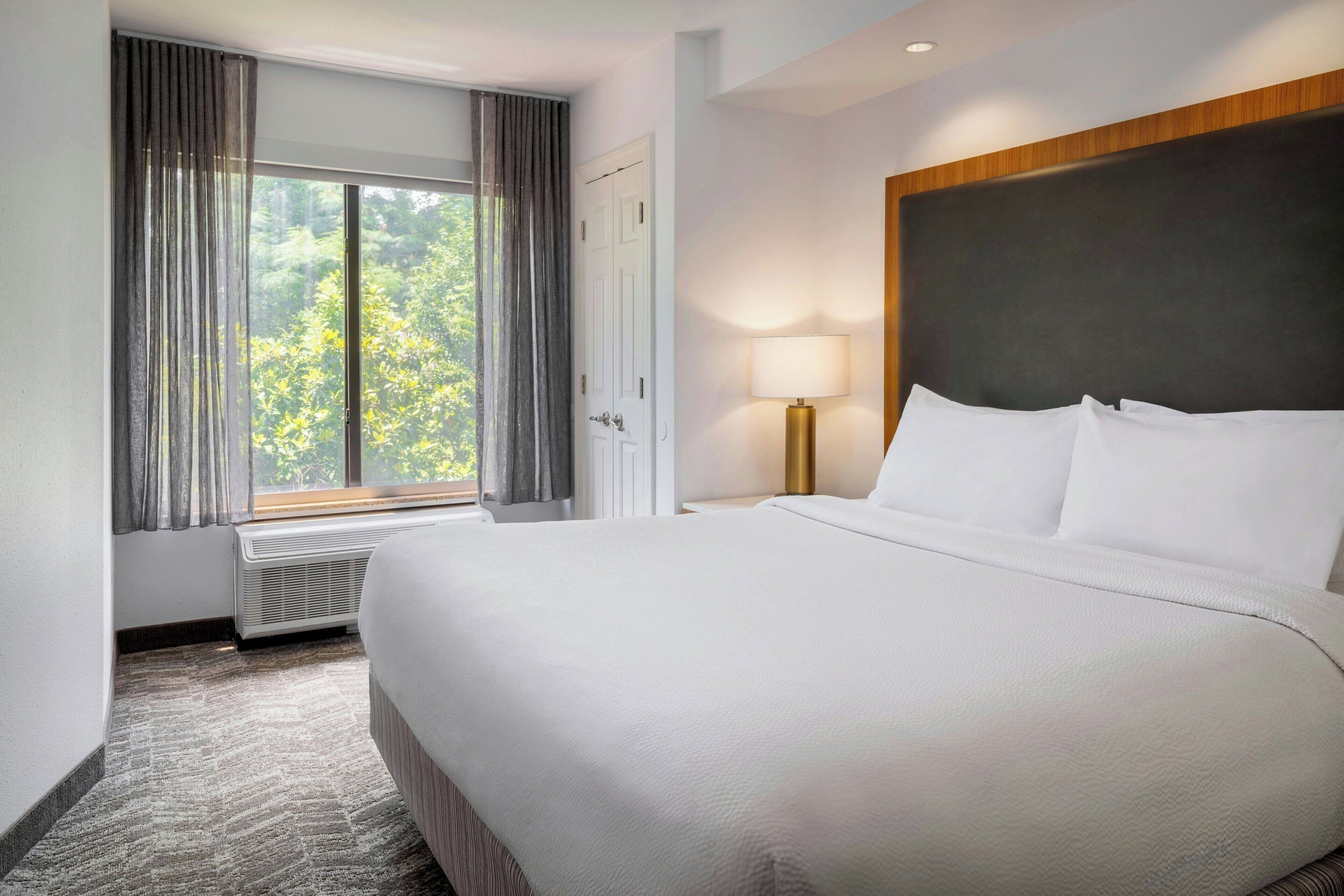 Premium bedding, desk, laptop workspace, blackout drapes