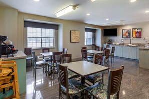 Enjoy meals and social gatherings in this inviting dining area with a central island, comfortable seating, and large windows offering views of the outdoors.