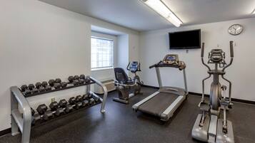 A gym with treadmills, an elliptical, and a rack of dumbbells.