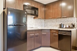 Una cocina moderna con electrodomésticos de acero inoxidable, armarios de madera y un salpicadero decorativo.