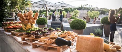 A food display with various cheeses and meats, wooden serving boards, and a chalkboard sign.