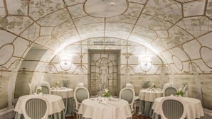 A dining area with round tables, chairs, and a ceiling with a geometric pattern. - Hotel Ponte Sisto (Rome)