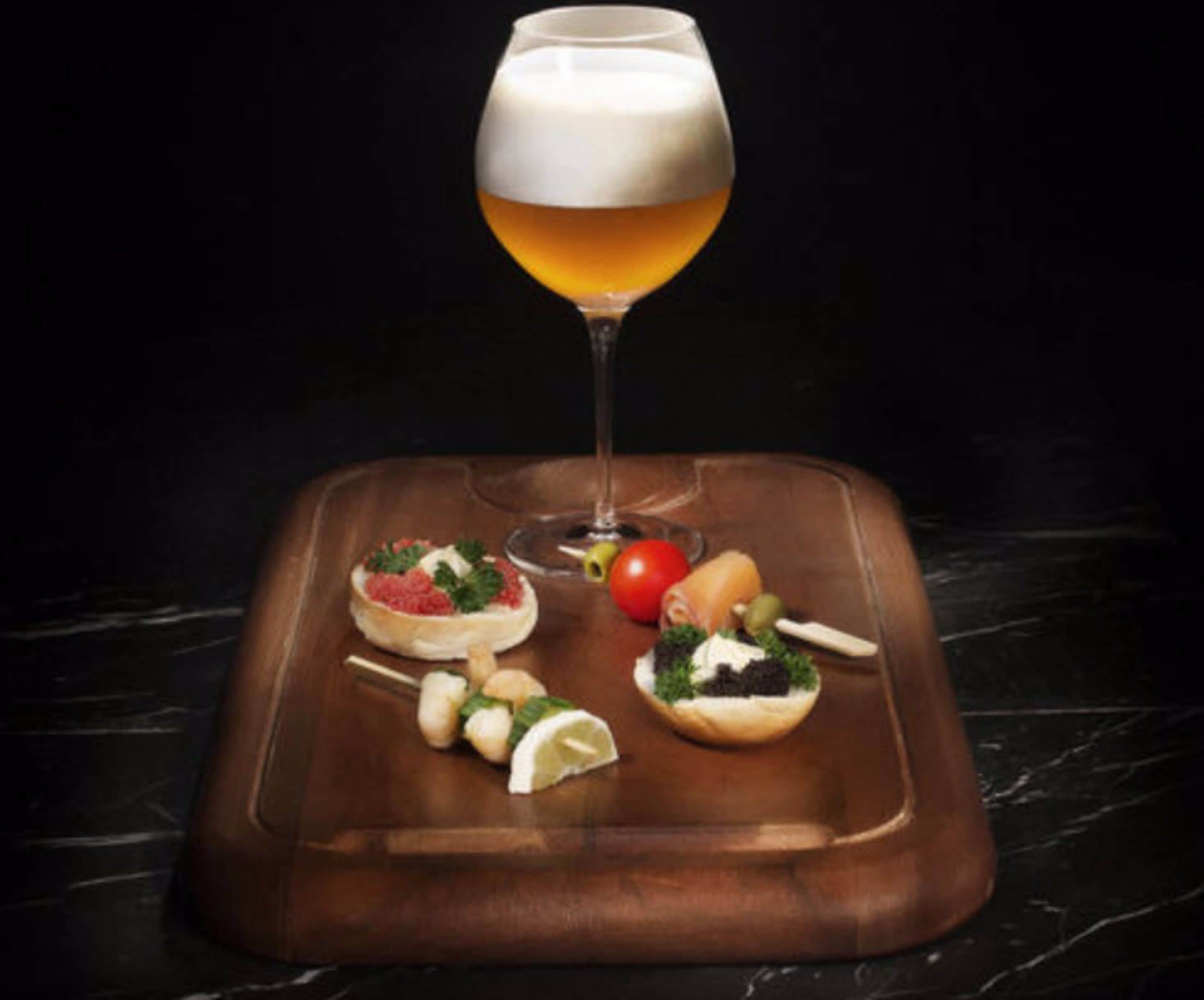 A tray with a glass of beer and various snacks.