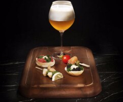 Un plateau avec un verre de bière et divers amuse-gueule.
