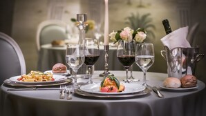 A formal dining table set with plates of food, wine glasses, and a candle. - Hotel Ponte Sisto (Rome)