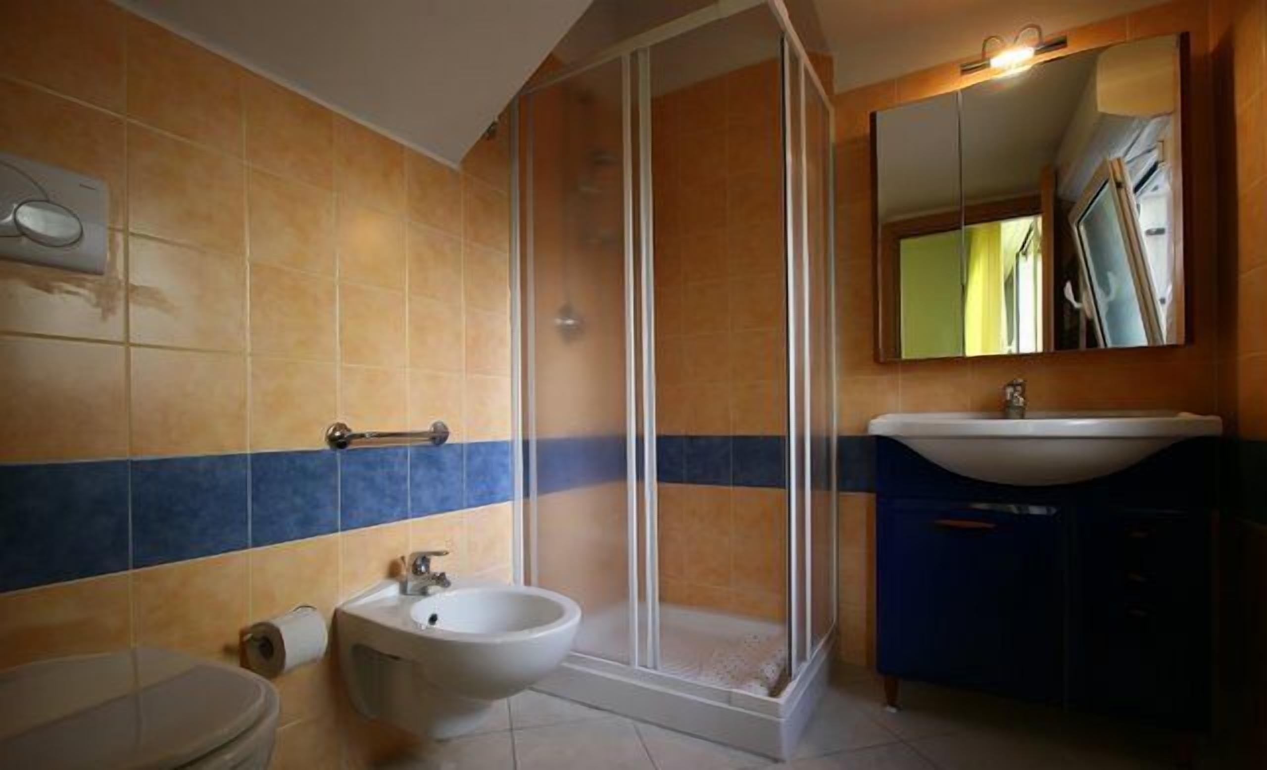 A bathroom with a shower, sink, and toilet.