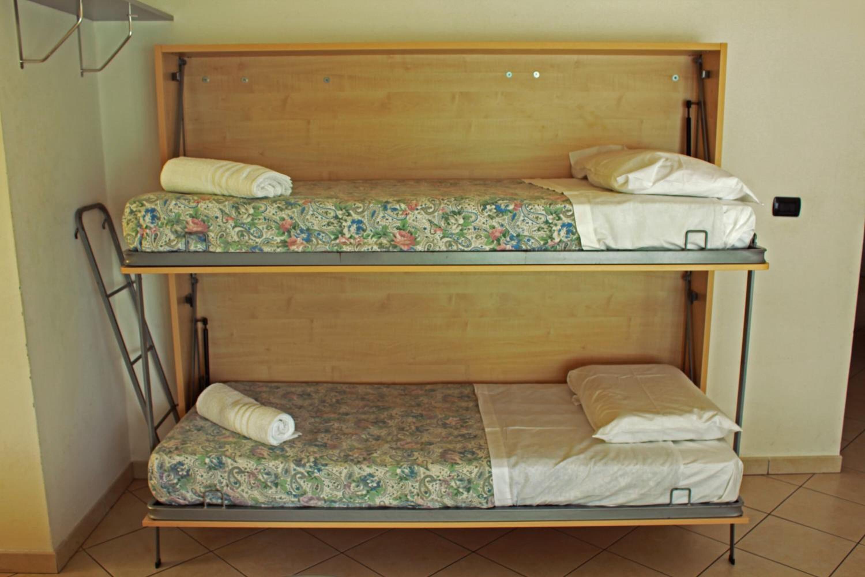 A bunk bed with two levels, each with a mattress and pillows.