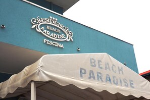 Un edificio con un letrero que dice "RESIDENCES BEACH PARADISE PISCINA".