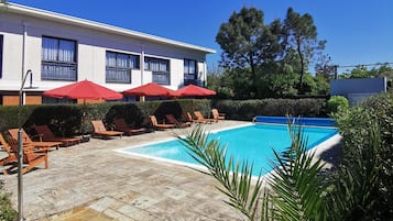 Piscine extérieure, parasols de plage, chaises longues