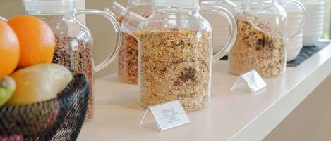 A display of granola jars on a counter with a sign indicating 'Cereals' and 'Granola'.