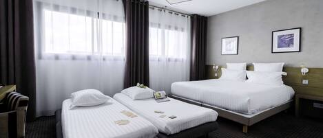 Habitación de hotel con dos camas, un escritorio y una silla.