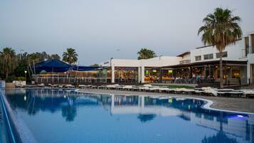 Una piscina cubierta, una piscina al aire libre de temporada, sombrillas