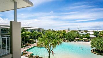 Relax by the pool surrounded by lush greenery and palm trees.