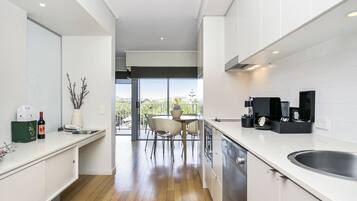 Een moderne keuken met een groot eiland, een eethoek met stoelen en uitzicht op het buitengebied.
