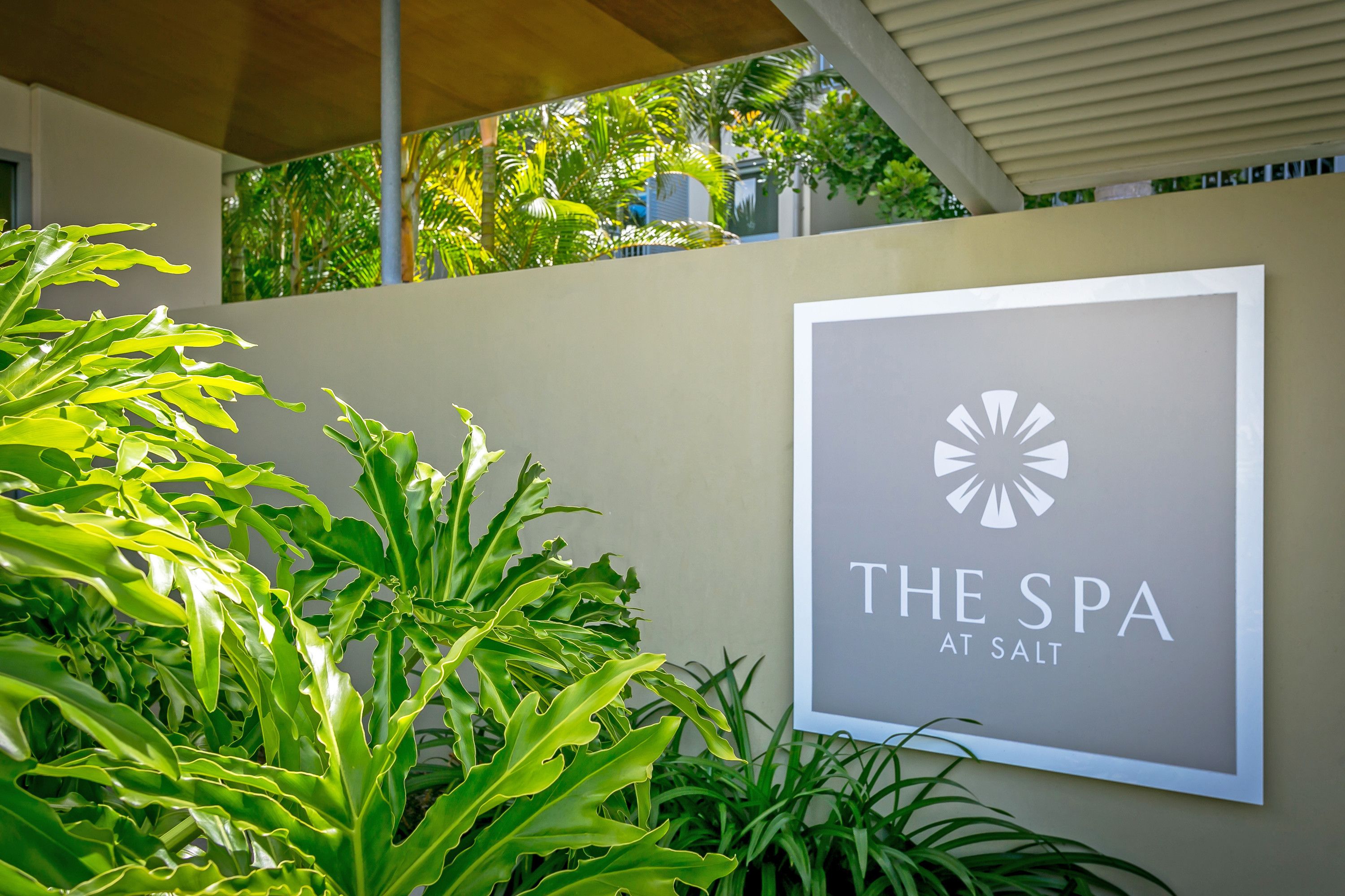 A spa sign with a logo and the text "THE SPA AT SALT" on a wall.