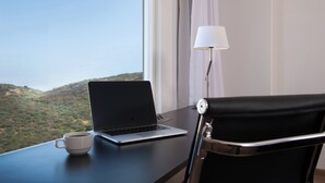 Ein Laptop auf einem Schreibtisch mit Tasse, Lampe und Stuhl.