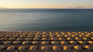 A beach with rows of sun loungers and umbrellas. - Mitsis Norida (Kos)