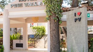 A hotel entrance with a sign reading "HOTEL PINE VALLEY" and a pillar with "I ♥ PV" engraved on it. - Hotel Pine Valley (Fethiye)