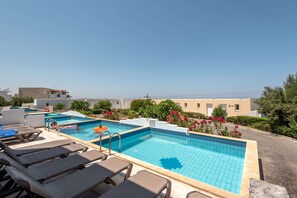 Ein Pool auf dem Dach mit Liegestühlen und freiem Blick auf das Meer.