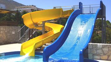 Un parc aquatique avec deux toboggans, un jaune et un bleu, et une zone avec des piscines.
