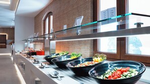 A buffet with various dishes and a glass railing. - Roda Beach Resort & Spa All-inclusive (Corfu)