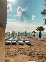 En la playa, camas de playa, sillas reclinables de playa, sombrillas