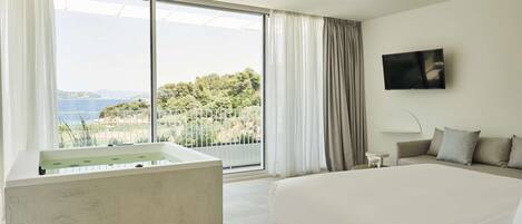 A modern bedroom with a large bed, a bathtub, and a TV.